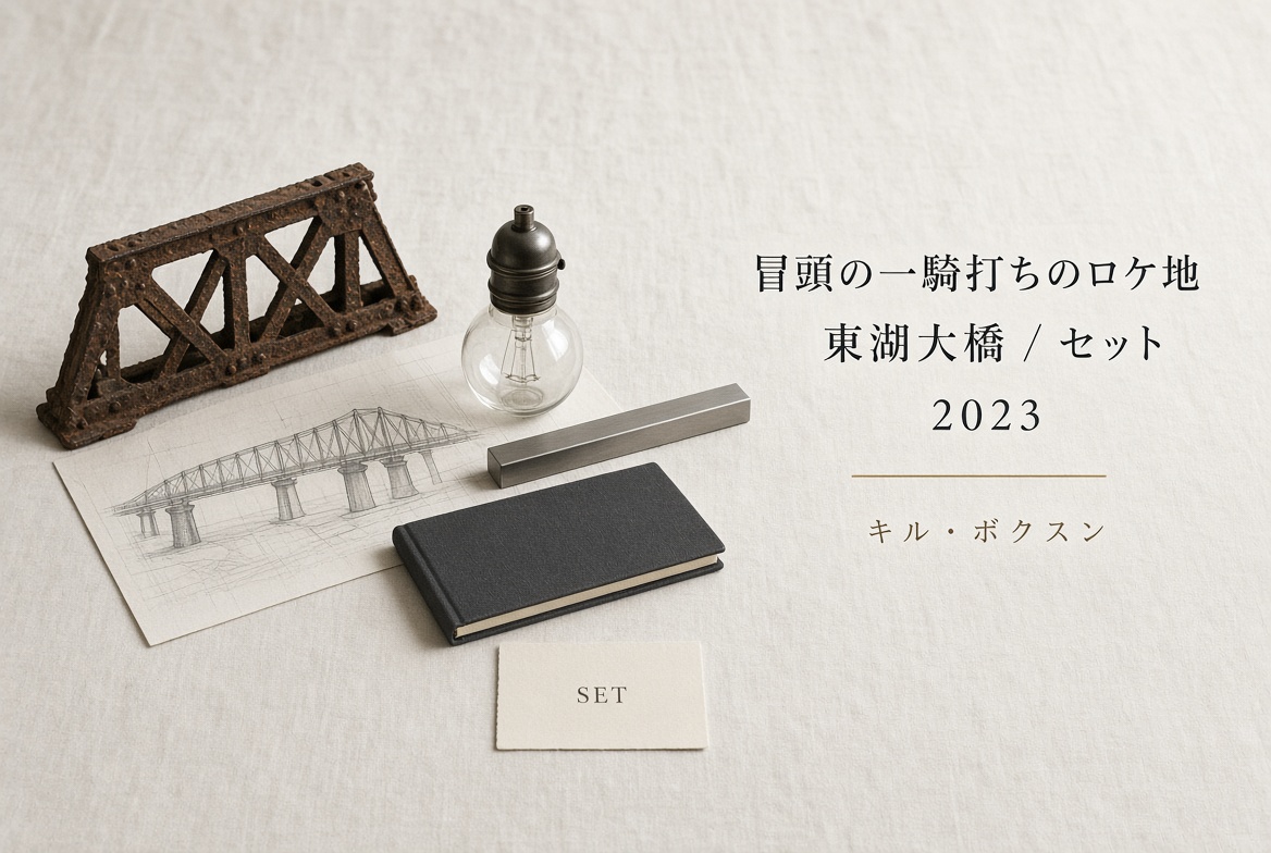 象牙色の布の上に、錆びたトラスの模型、鉄橋の鉛筆スケッチ、スタジオ用の電球、細い鋼材、閉じた黒いノート、SETと印刷したカード。右に「冒頭の一騎打ちのロケ地／東湖大橋 / セット／2023／キル・ボクスン」。人物はいない。
