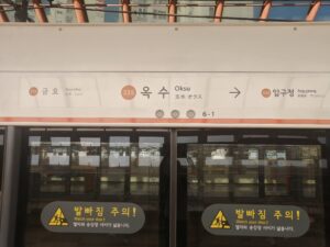 3号線玉水駅ホームドア上の案内。左334金湖、中央335玉水、右矢印336狎鷗亭。ドアには足元注意の黄色いステッカー。