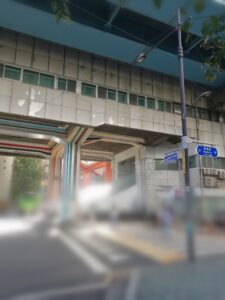 ソウル・玉水洞。東湖路24–28の青看板と、3号線高架下の虹色に塗られた柱。手前の横断歩道は、ぼかしを入れて歩行者を特定できないようしている。